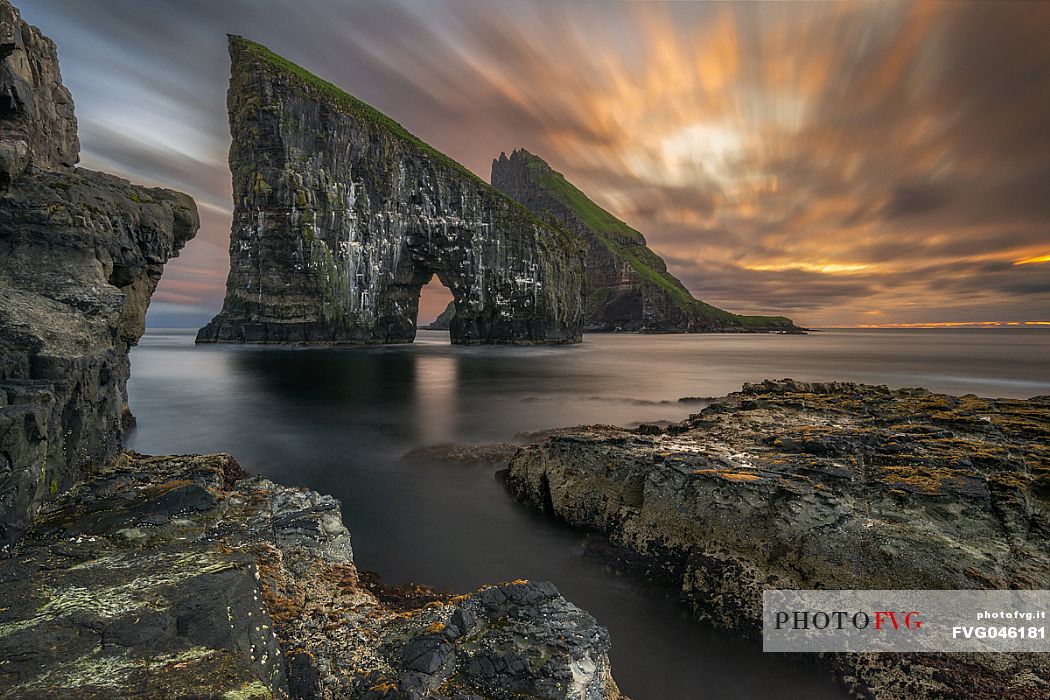 Beautiful sunset on Drangarnir rocks, two sea stacks which are called Stri Drangur (large rock) and Ltli Drangur (small rock) respectively, and are located next to each other between the islands of Vgar and Tindhlmur, Srvgsfjrur Fjord near Srvgur, Faeroe islands, Denmark